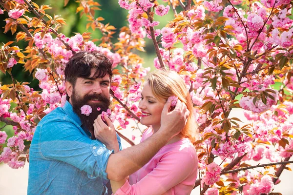 У пары свидание в весеннем цветущем парке в весенний день с красивыми цветами вишни на заднем плане. Пасхальная пара , — стоковое фото