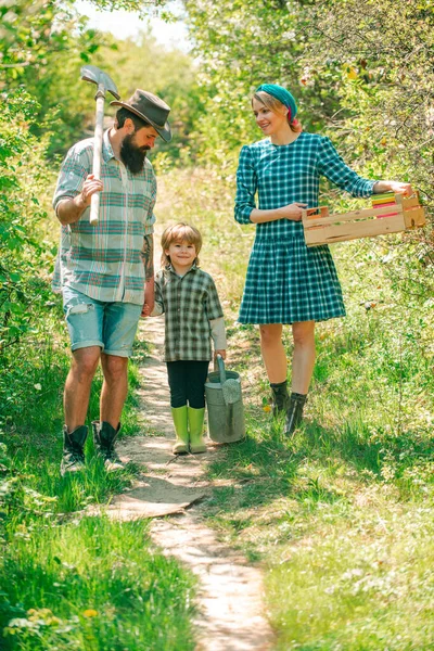 Familia trabajando juntos en la granja. Familia con su hijo trabajando en la granja orgánica en primavera. Me encantan nuestros momentos en el campo . — Foto de Stock