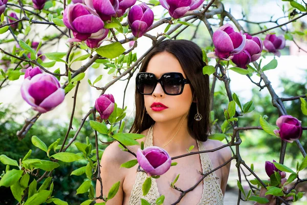 Retrato de una hermosa joven morena. Hermoso retrato soleado de una chica con gafas de sol de moda . — Foto de Stock