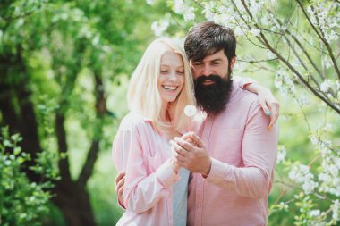 Birbirine aşık çiftler gülüp sarılıyorlar. Çiçek açan bahçede eğlenen bir çift. Güneşli bahar gününde bir çift. Aşık Çift.