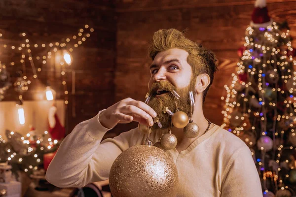 Retrato del guapo Papá Noel en el interior con bola de Navidad, adorno de oro. Tema Vacaciones de Navidad e invierno año nuevo. Papá Noel con barba blanca posando sobre el fondo de madera de Navidad . —  Fotos de Stock