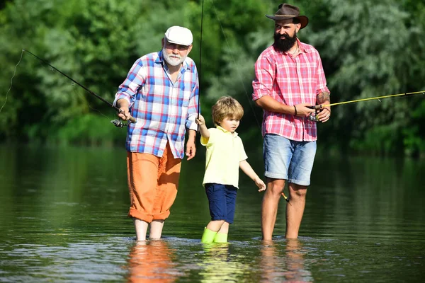 Pesca. Weekend estivo. Padre e figlio pescano. Pesca nel fiume. Tre generazioni di età: nonno, padre e giovane figlio adolescente. Felice giorno dei padri . — Foto Stock