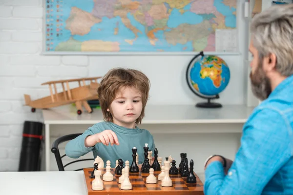 Schaakschool voor kinderen. Een kleuter of een schooljongen, een jongen die thuis schaakt. Spelen en activiteiten voor kinderen. Gezinsconcept. — Stockfoto