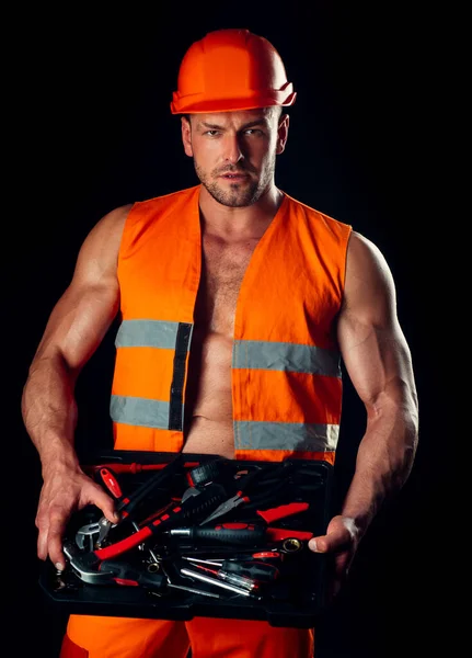 Retrato de operário masculino. Retrato de belo reparador segurando chave sobre fundo preto . — Fotografia de Stock