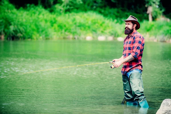 Handsome man relaxing. Summer weekends or vacation. United with nature. Fishing by the lake. Summer weekend. Fly fish hobby of men in checkered shirt. Pothunter. Rest and recreation. — Stock Photo, Image