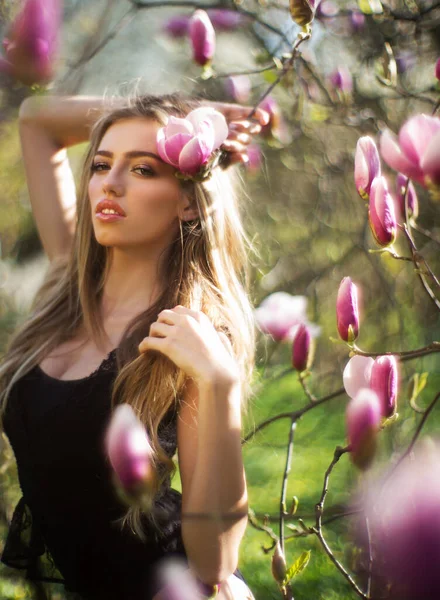 Mulher loira bonita nova no jardim florescendo. Mulher natural bonita com flores. Retrato de menina da primavera. Retrato de beleza do rosto feminino com pele natural. Foto de moda primavera. Conceito de cuidados da pele — Fotografia de Stock