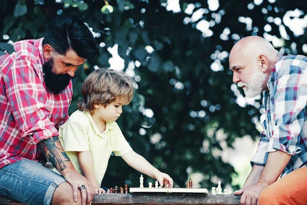 Mutlu bir aile. Satranç oyunu gibi. Satranca bayılırım. Sağlıklı yaşam tarzı kavramı. Satranç stratejisi geliştiren sevimli çocuk. Rehabilitasyon merkezinde kıdemli adam antrenmanı. — Stok fotoğraf