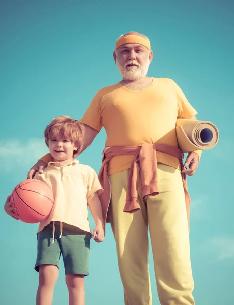 El abuelo y el niño hacen ejercicio matutino. Entrenamiento de ancianos en el centro de rehabilitación. Vida sana y activa en cualquier concepto de edad . — Foto de Stock