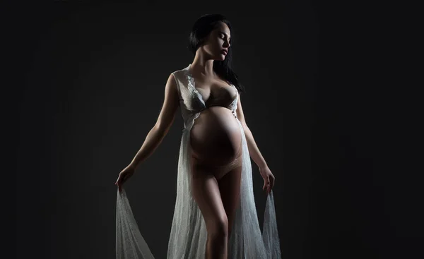 En gravid kvinnas mage. Graviditet. Kvinna studio intimt porträtt. Lycklig gravid kvinna. Lycklig gravid. Isolerad på svart studio bakgrund. — Stockfoto