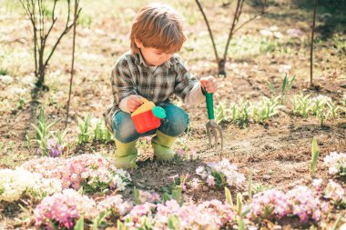 Bahar bahçesinde çocuk oyunu. Dünya günü. Bahar bahçesinde yürüyen sevimli çocuk. Bahçedeki çocuk bahçesinde..