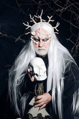 Keskin dikenleri ve yüzünde siğiller olan bir canavar. Sihir ve masal kavramı. Kötü vampir adam. İblis suratlı harika bir büyücü adam. Siyah zemin üzerinde Druid.