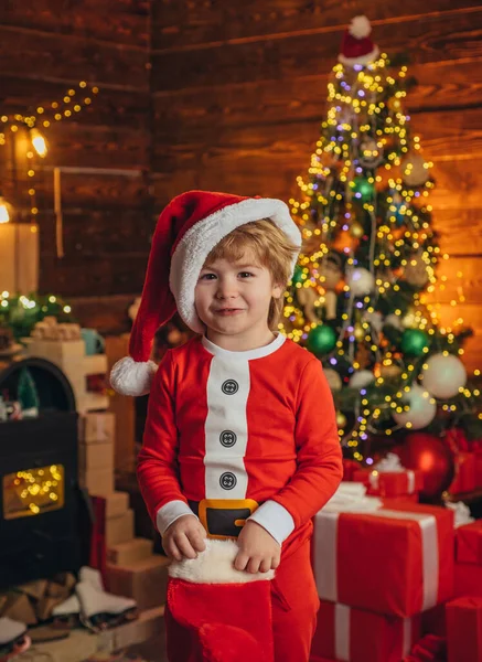 Szczęśliwy dzieciak bawiący się prezentem. Szczęśliwy mały uśmiechnięty chłopiec ze skarpetkami świątecznymi. — Zdjęcie stockowe