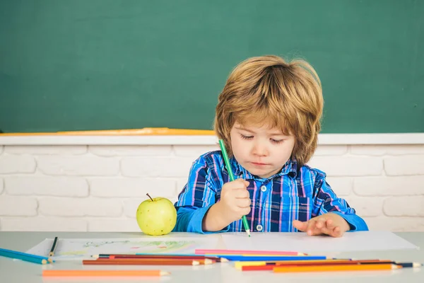 Általános iskolás. Egy gyerek a táblánál az osztályteremben. Boldog iskolás gyerekek az órán. — Stock Fotó