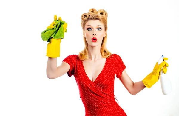 Schoonmaakconcept. Beauty pin up vrouw in beschermende handschoenen is glimlachen en vegen stof met behulp van een spray en een stofdoek tijdens het schoonmaken van haar huis. Grappige huishoudster. — Stockfoto