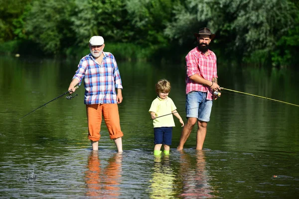 Nonno, padre e nipote pescano insieme. Veniamo insieme. Pesca a mosca. Padre insegna a suo figlio la pesca contro la vista del fiume e del paesaggio . — Foto Stock