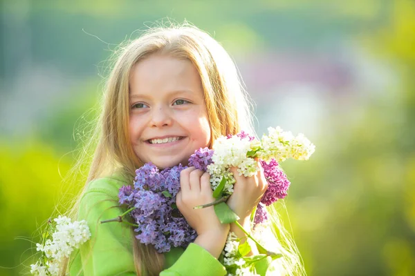 Young spring girl in spring garden. Young lady feeling happy in nature. Facial portrait of funny teenager girl. Girl with bouquet of lilac. — Stock Photo, Image