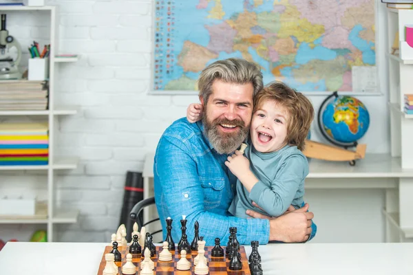 Ojciec i syn relaksują się razem. Rodzicielstwo. Nauczyciel pomaga chłopcu w szachach. Ludzie pokoleń. Rodzinne wakacje i wspólne spędzanie czasu. — Zdjęcie stockowe