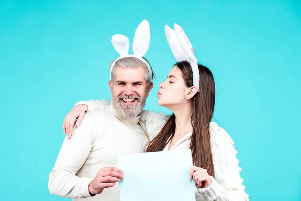 Påsk kanin par hålla ombord papper för text. Familjepar klädda i kostym påsk kanin på blå bakgrund isolerad. Kaninpar firar påsk. — Stockfoto