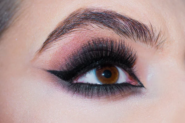 Schöne Makroaufnahme des weiblichen Auges mit extrem langen Wimpern und rauchigem Make-up. Nahaufnahme Makroaufnahme von Modeaugen Visage Make up eyes. Augenbrauen in Großaufnahme, lange Wimpern. — Stockfoto