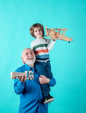 Büyükbaba ve torunun oyuncaklarla oynadığı portre. Aile İlişkisi Büyükbaba ve Torun. Erkek Aile Kavramı. Pozitif çocuk, büyükbaba ve torun mavi arka planda izole edilmiş..