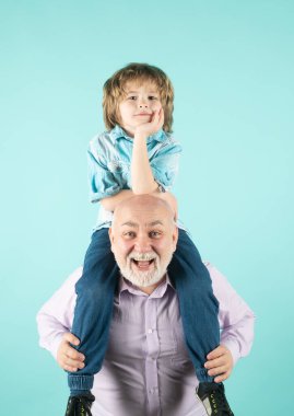 Kıdemli adam torununu sırtında taşıyor. Erkek Aile Kavramı. Pozitif Çocuk, Baba ve Oğul.
