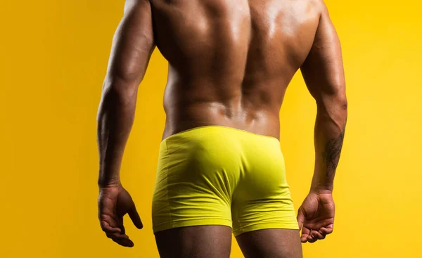 Man buttocks in yellow underpants. Muscular man with muscular buttocks. Bare nude torso, Naked male ass. — Stock Fotó
