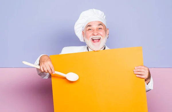 Glückliche Stunden. Cafe Shop Werbung. Bärtiger älterer Herr in Schürze. Koch mit Kopierraum an der Tafel. Chefkoch isoliert auf Farbe. Koch kocht. — Stockfoto