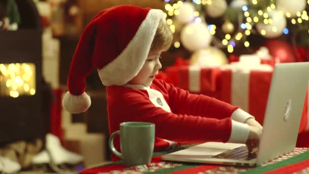 Sconto nel negozio online, negozio di Natale su Internet. Felice bambino carino in cappello di Babbo Natale con laptot, computer hanno un Natale. Shopping online di Natale . — Video Stock