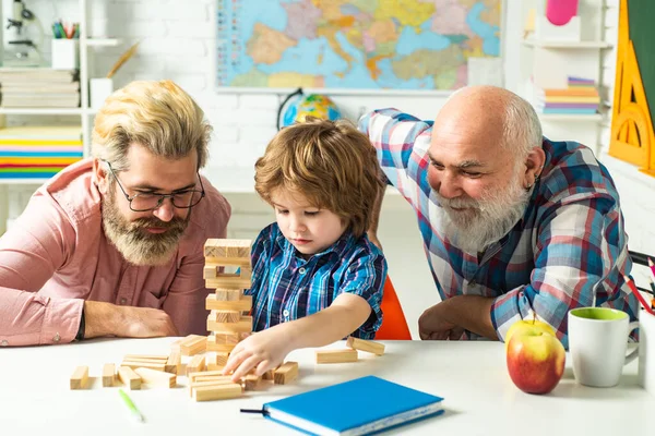 Albero genealogico. Allievo con padre e nonno che si divertono insieme a casa. Insegnare eccitato. Tre generazioni diverse età: nonno padre e figlio figlio insieme . — Foto Stock