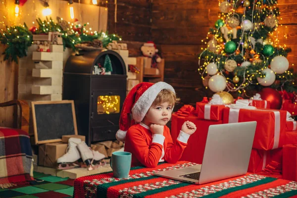 Niño inteligente con alegres regalos de compras de la cara a los padres calcetín de Navidad. El niño de Navidad sueña. Comprar regalos de Navidad en línea. Ayudante de Santa . —  Fotos de Stock