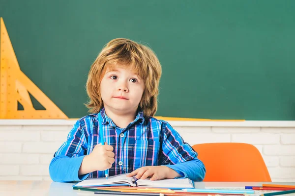 学校の教室で黒板の近くの子供。１日目だ。個人指導。教育。小さい学生男の子幸せなです素晴らしいマーク. — ストック写真