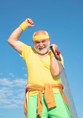 Kıdemli adam mavi gökyüzünde egzersiz yapıyor. Sağlıklı yaşlı bir sporcunun portresi. Son sınıf öğrencisi fitness eğitimi alıyor. Sportif. En iyi kardiyo çalışması.