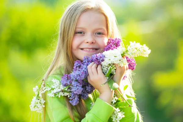 Spring girl in blooming garden. Funny little girl in a blooming garden. Teenager girl with bouquet of lilac. Happy smiling teenager girl with spring flowers. — Stock Photo, Image