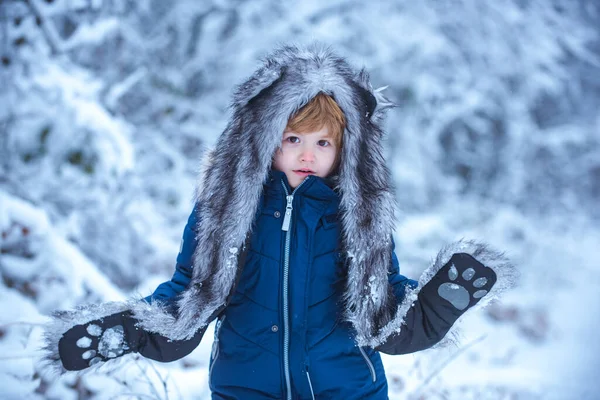 Barn i vinterparken. Söt liten pojke leker i vinterparken i snö utomhus. — Stockfoto