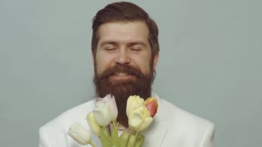 Elinde lale buketi tutan adam, bahar, 8 Mart. Mutlu ve aşık. Sevgililer Günü. Bir buket çiçeğin arkasına saklanan bir adam. Teklif sahnesi.