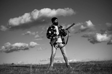 Silah tutan ve ormanda yürüyüş sakallı avcı adam. Hunter avı av tüfeği silah ile.