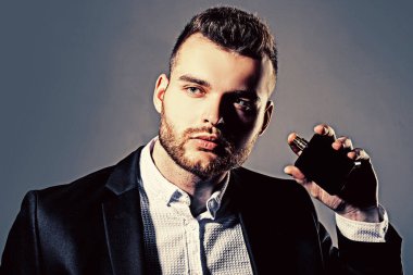 Erkek parfümü konsepti. Parfüm için zarif bir adam. Erkeksi parfüm. Parfüm. Erkek parfümü, parfüm, kozmetik. Elinde parfüm şişesi tutan bir adam. Parfüm şişesi.
