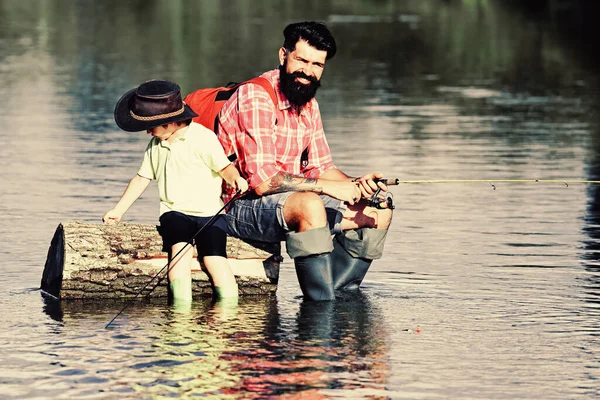 Padre e hijo pescando juntos. Le gusta hablar con papá. Concepto de edad de jubilación. Feliz padre e hijo pescando en el río sosteniendo cañas de pescar . — Foto de Stock