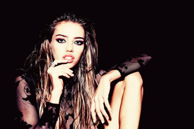 Renkli makyajlı, yüksek model bir kadın. Stüdyoda koyu arkaplanda poz veren dumanlı göz makyajlı güzel bir kızın yüzü..