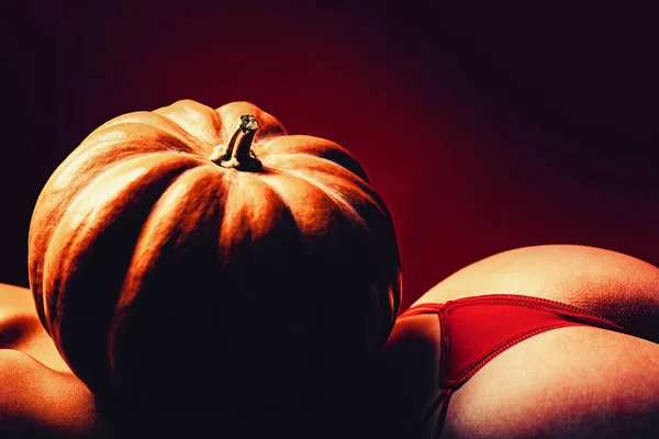 Celebrates Halloween. Pumpkin on woman with sexy butt and back. Copy space. Sale on lingerie. Sensual butt with hallowen pumpkin. Celebrates and autumn sale. — Stockfoto