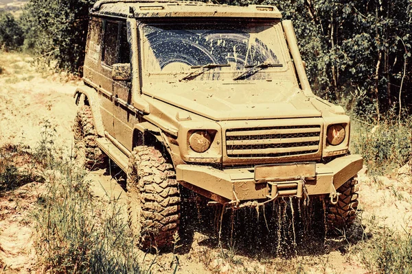 Lama e água salpicam para fora da corrida de estrada. Vestígios num campo lamacento. Viagem off-road na estrada da montanha. Trekking de viagem 4x4 . — Fotografia de Stock