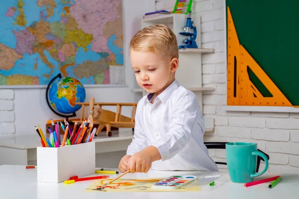 Leuke kleine kleuter jongen met leraar studie in een klaslokaal. Basisschool en onderwijs. Na het schoolonderwijs. — Stockfoto