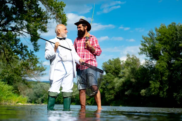 Buon pescatore barbuto in acqua. Uomo anziano in giacca e cravatta con asta e pesce. Weekend fatti per la pesca. La pesca è divertente. Vacanze estive. Uomini pesca rilassante mentre godendo hobby. Divertiti. . — Foto Stock