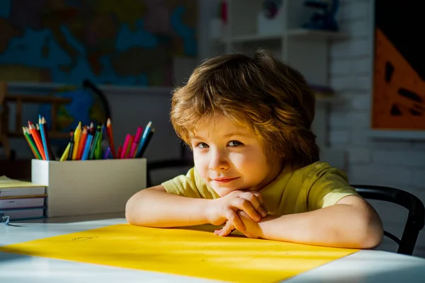 Słodki chłopiec w klasie w pobliżu biurka tablicy. Uczeń uczy się liter i cyfr. Uczenie się dzieci. — Zdjęcie stockowe