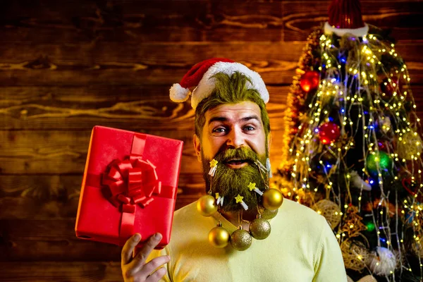 Δώρα παράδοσης. Πρωτοχρονιά, Χριστουγεννιάτικη κάρτα. Hipster σύγχρονο Santa Claus ευχές Καλά Χριστούγεννα. Στυλ Άγιος Βασίλης με μακριά γενειάδα ποζάρουν στο ξύλινο φόντο. — Φωτογραφία Αρχείου