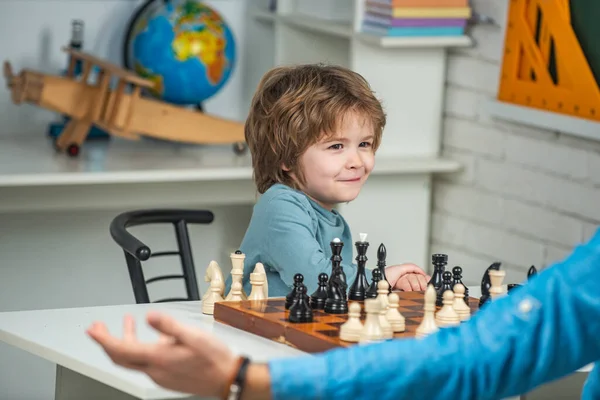 Like chess game. Family holiday and togetherness. Kid playing chess in the classroom. Boy think or plan about chess game - style for education concept.