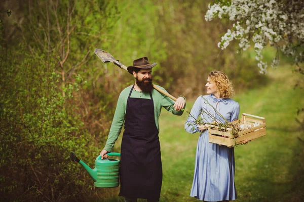 Erdkonzept. Bild von zwei glücklichen Bauern mit Instrumenten. Ein Bauer und seine Frau stehen auf ihrem Feld. Bauernpaar bei der Feldarbeit. — Stockfoto