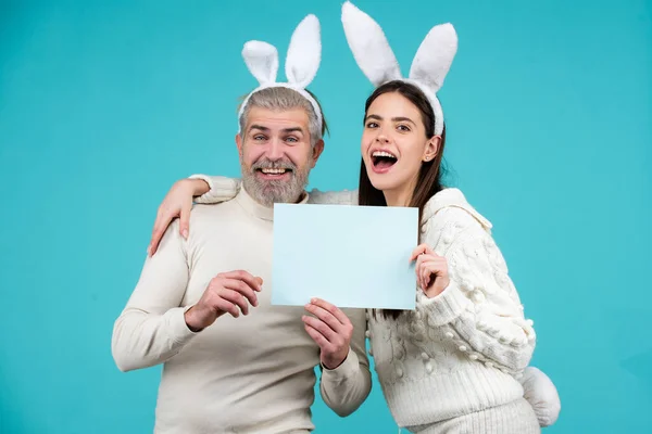 Glad påsk för ditt sällskap. Kanin: upprörda kaninpar. Porträtt av glad påsk kanin man och kvinna hålla pappret för text. påsk kanin par på blå bakgrund isolerad. — Stockfoto