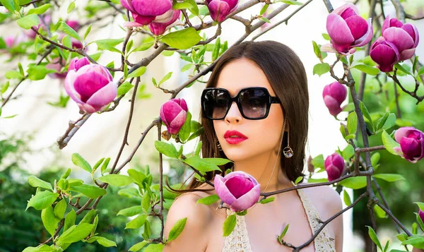 Retrato de modelo de belleza con gafas de sol. Belleza Cara de mujer Retrato en flor de Magnolia . — Foto de Stock