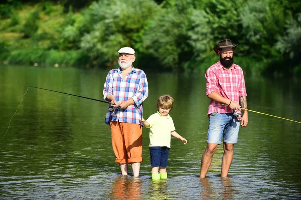 家庭联系。祖父、父亲和孙子一起钓鱼。小男孩和他的父亲和祖父在湖上. — 图库照片